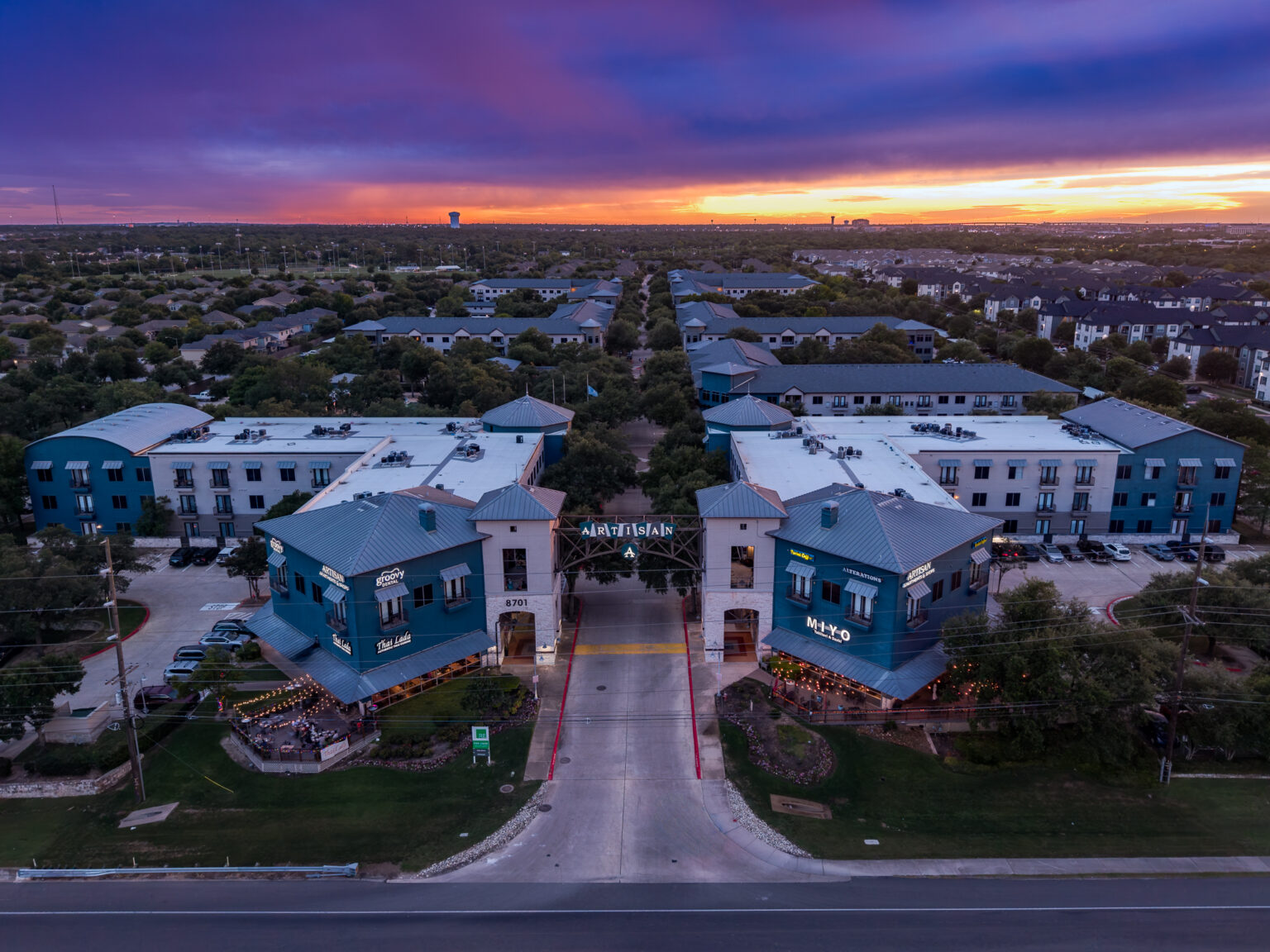 Twilight aerial of the Artisan apartments and shops in Austin — drone photography