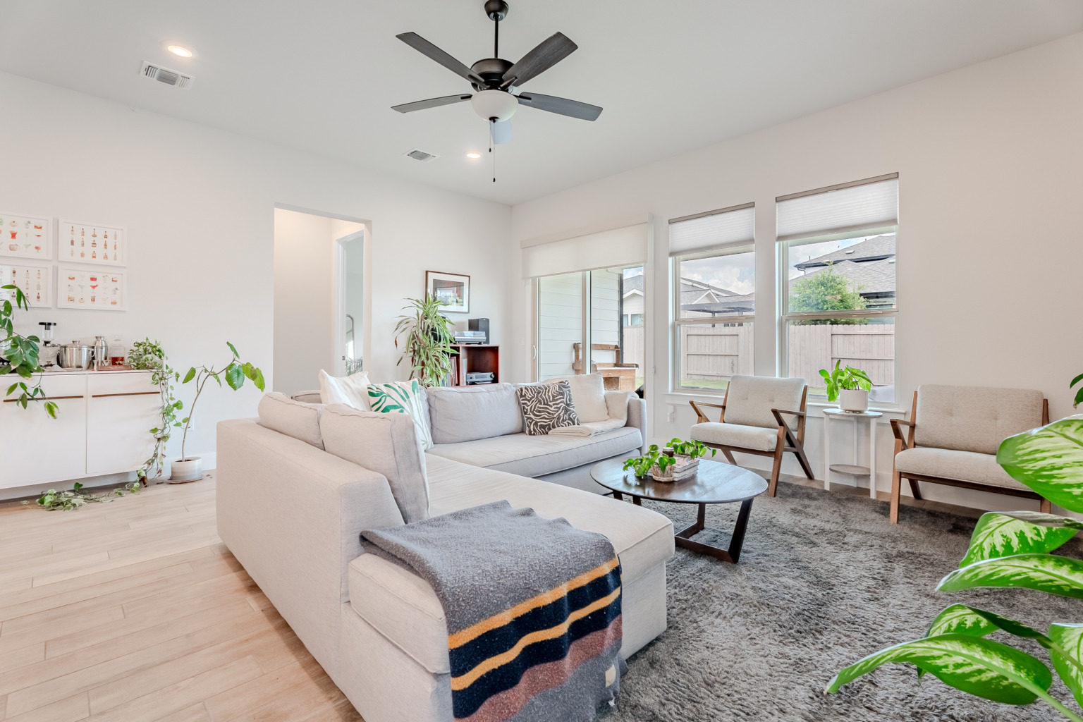 Bright living room with sectional and mid-century chairs — Austin real estate photography